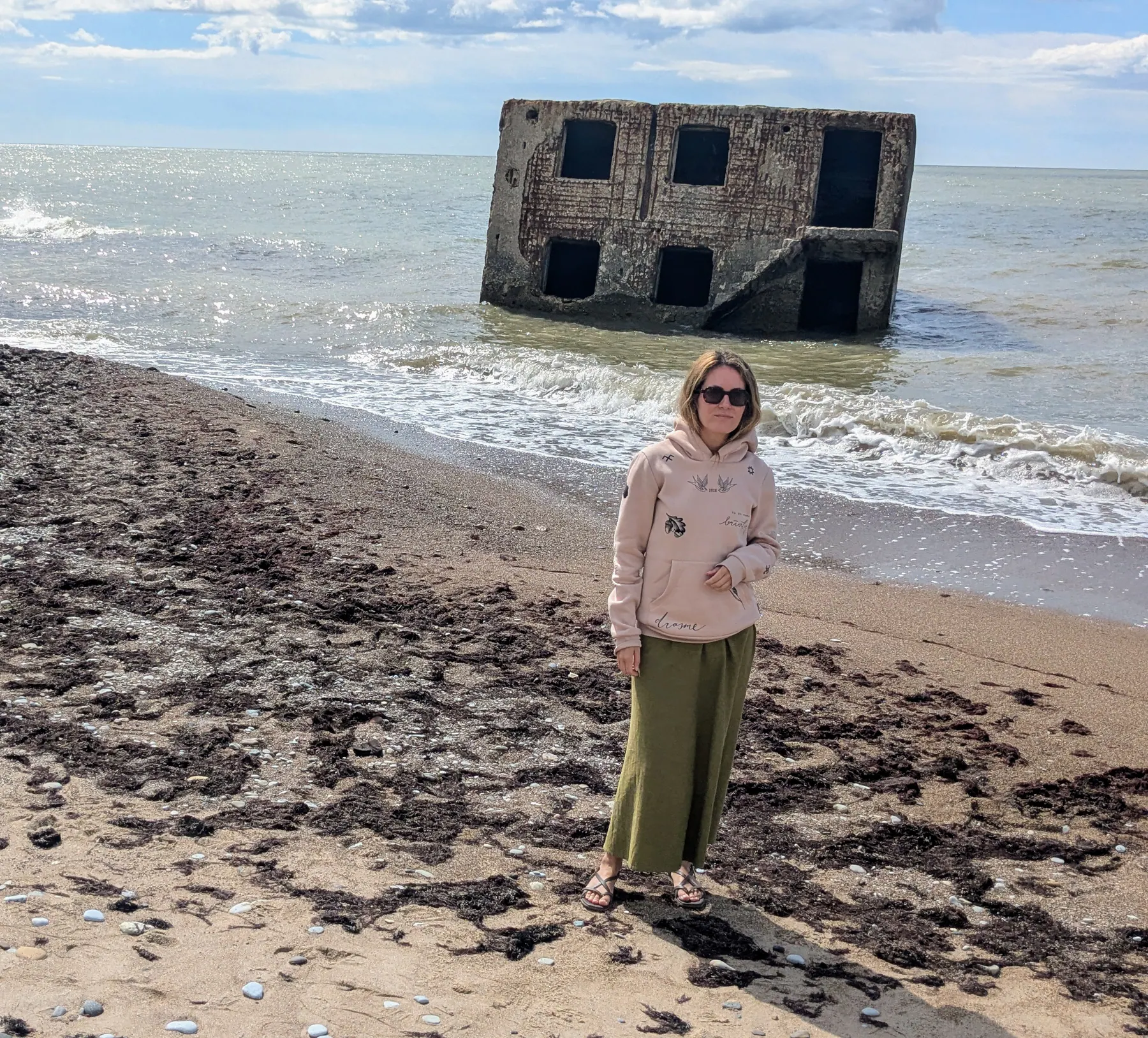A traveler beside the half-submerged ruins of Artillery Battery No. 3 near Liepāja