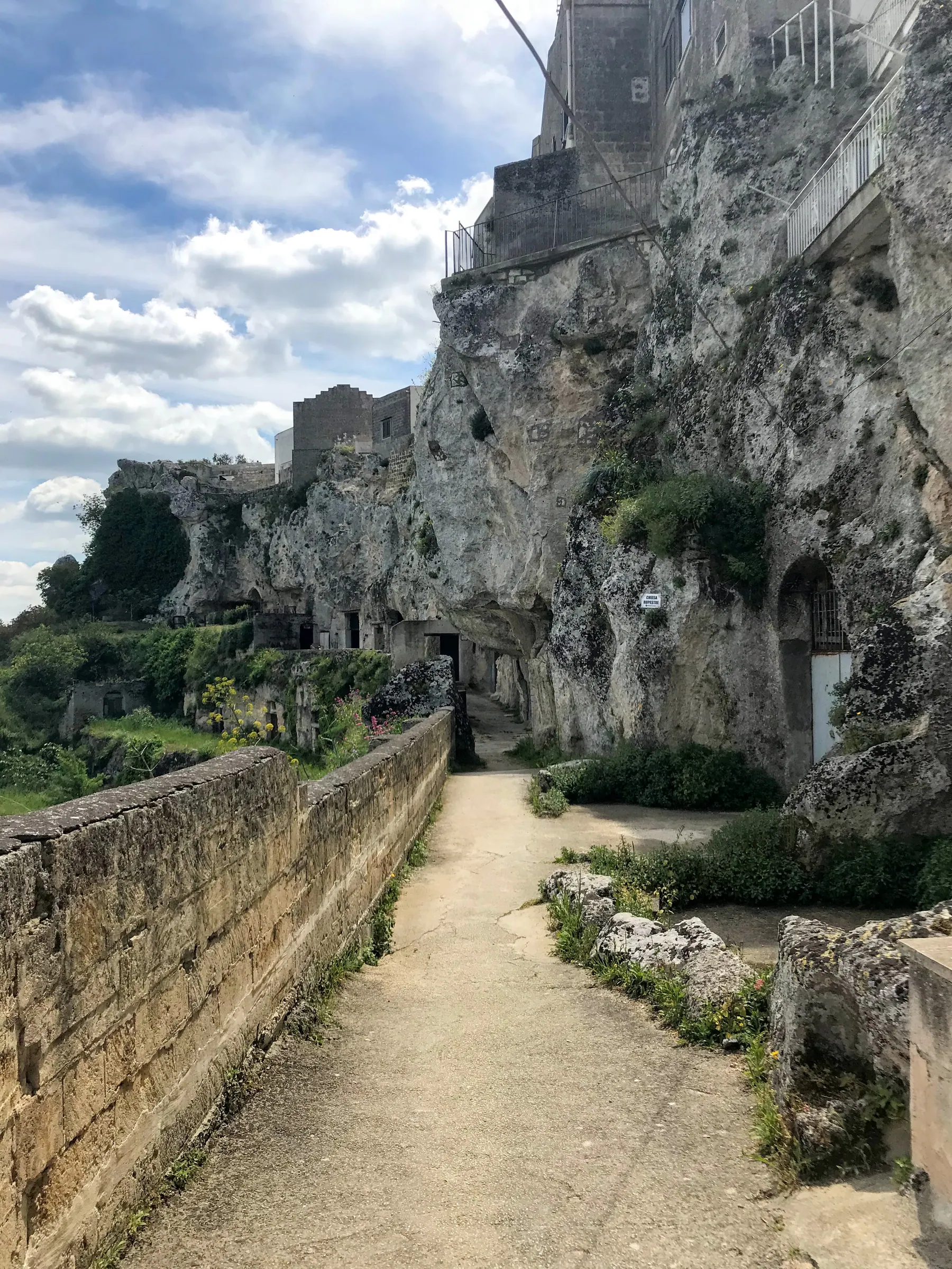 A narrow path through the raw cave dwellings of Rione Malve