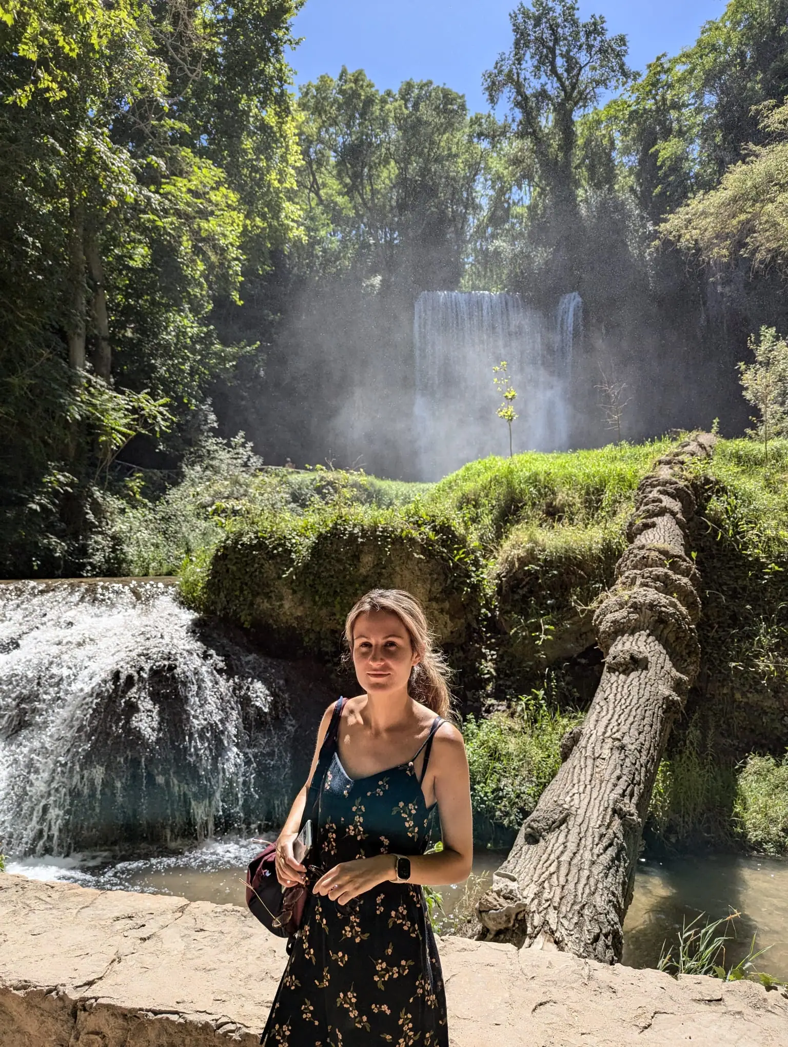 A traveler standing beside waterfalls and mossy paths in Monasterio de Piedra